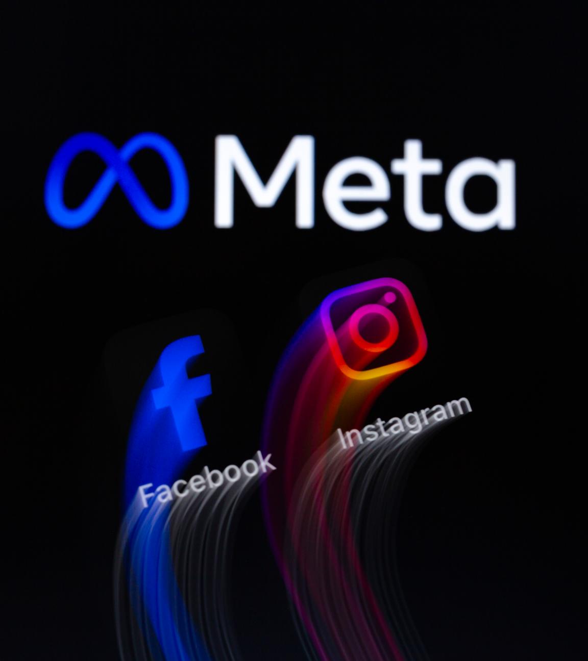Die Symbole der Facebook- und Instagram-Apps werden auf einem Smartphone vor dem Hintergrund des Logos von Meta Platforms angezeigt.
