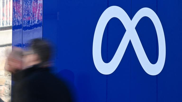 Personen vor dem Meta-Logo.