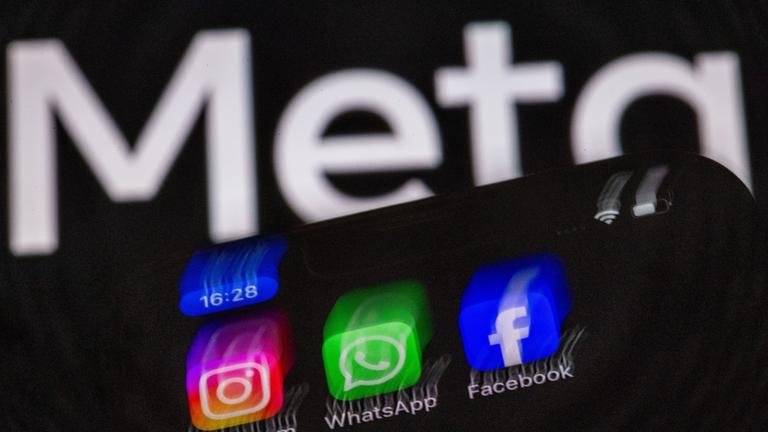 Die Apps Instagram, Facebook und WhatsApp sind auf dem Display eines Smartphones vor dem Logo des Internetkonzerns Meta zu sehen.