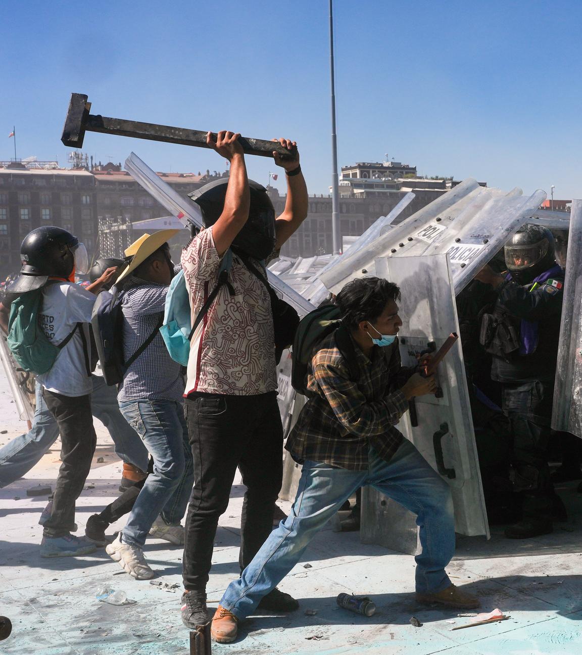 Demonstranten attackieren die Polizei während eines Marsches von Jugendlichen gegen die Regierung in Mexiko-Stadt. Ein Demonstrant schwingt eine Art Hammer.