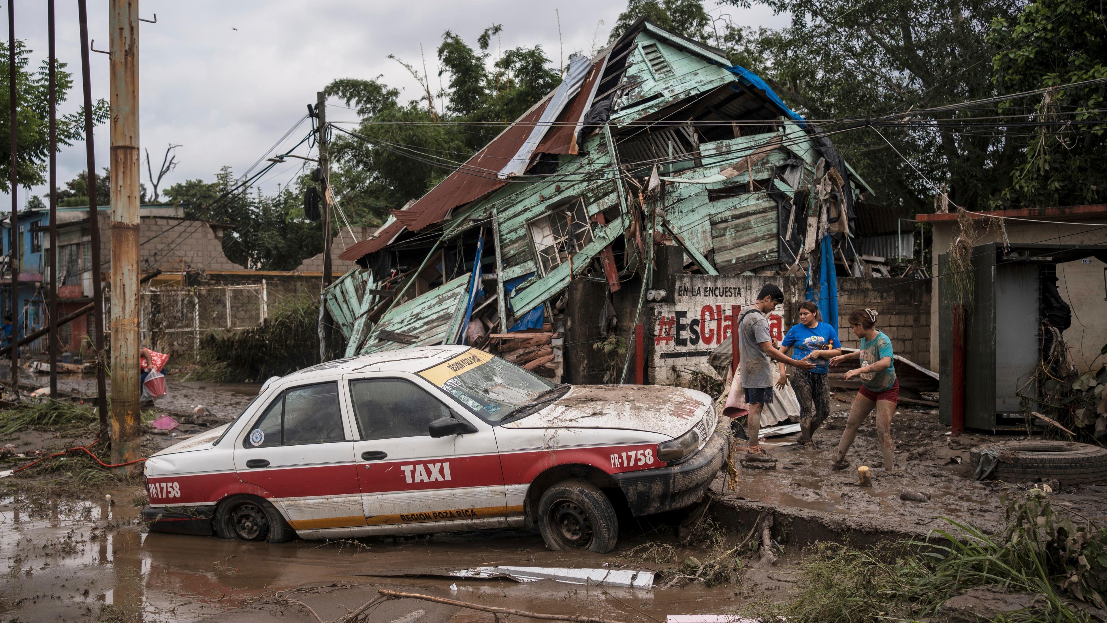 Nachbarn versammeln sich nach heftigen Regenfällen um ein beschädigtes Haus in Poza Rica, Bundesstaat Veracruz, Mexiko.