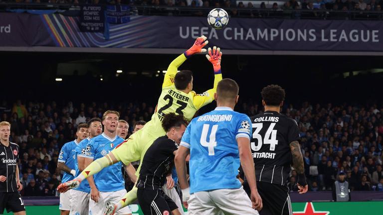 Michael Zetterer springt aus einer Gruppe Spieler heraus nach oben und blockt mit den Händen den heranfliegenden Ball ab.