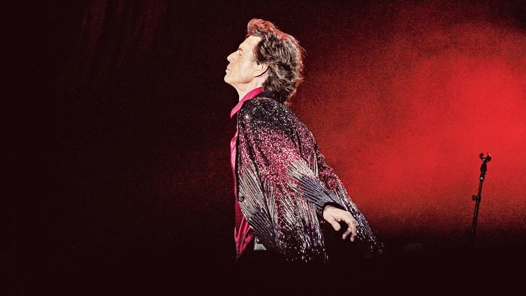 Der britische Sänger und Frontmann der Rolling Stones während eines Konzerts im Ciudad Deportiva in Havana, Kuba am 25. März 2016. Seitlich aufgenommen, gehend mit geschlossenen Augen vor rotem Hintergrund.