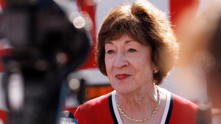 Susan Collins in einer Nahaufname. Sie trägt eine Stoffjacke und Goldschmuck.