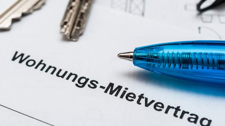 Kugelschreiber und Schlüssel liegen auf einem Mietvertrag.