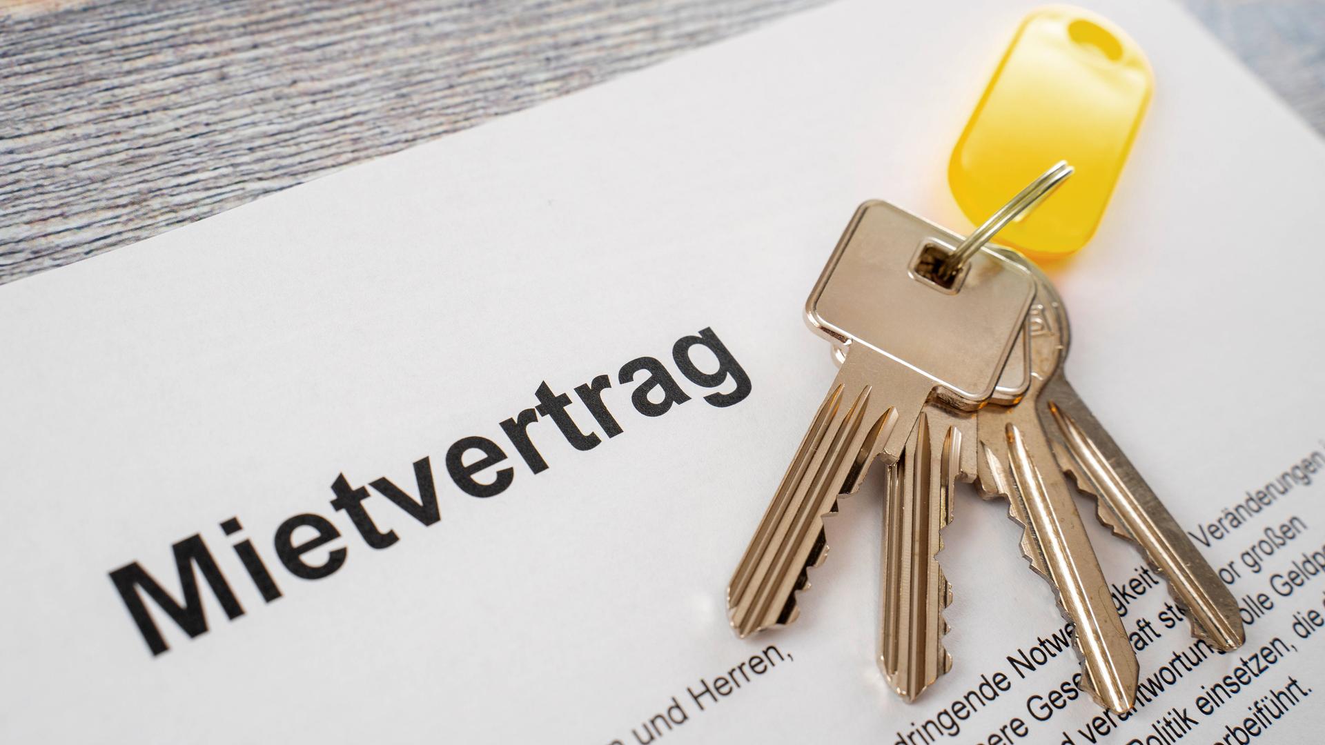 Wohnungsschlüssel liegen auf einem Mietvertrag in Nahaufnahme.