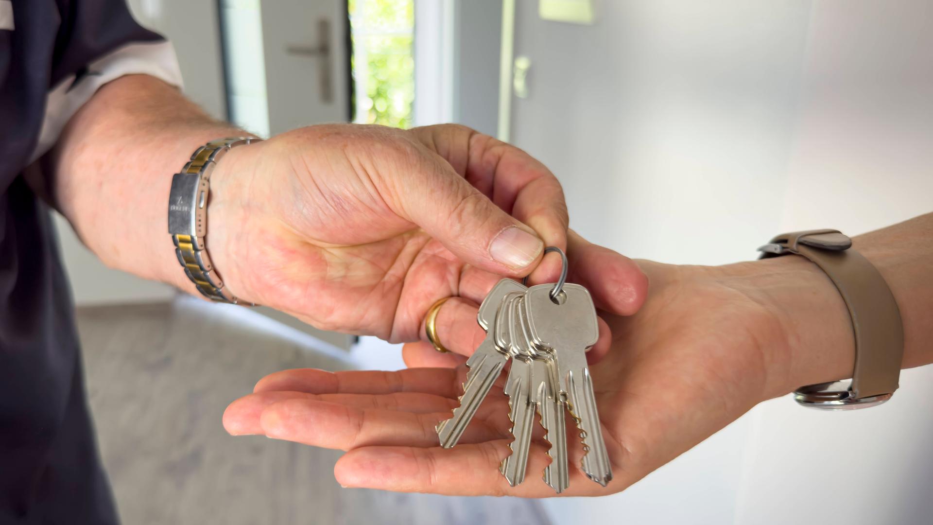 Ein Mieter übergibt seine Wohnungsschlüssel.