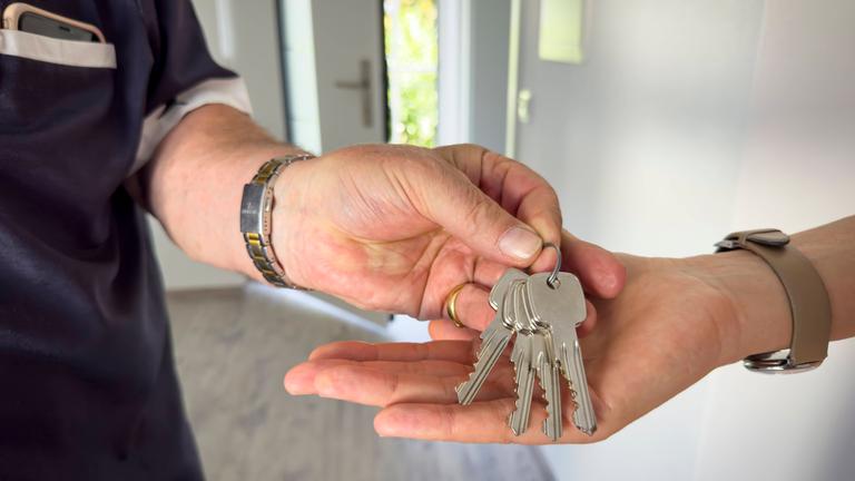 Ein Mieter übergibt seine Wohnungsschlüssel.
