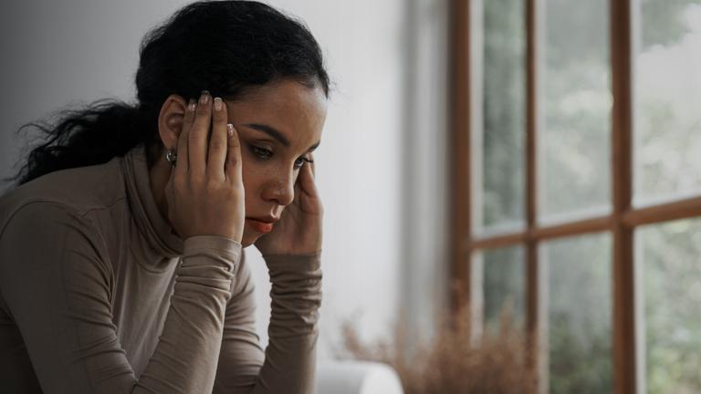 Erschöpfte Frau mit aufgestützen Ellbogen