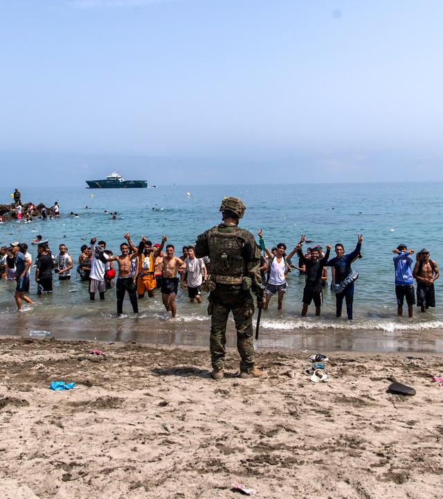 31.07.2026, Spanien, Ceuta: Spanische Armeesoldaten blockieren den Zugang zum Strand für Menschen, die von Marokko in die spanische Enklave Ceuta kommen. Foto: Antonio Sempere/AP/dpa +++ dpa-Bildfunk +++
