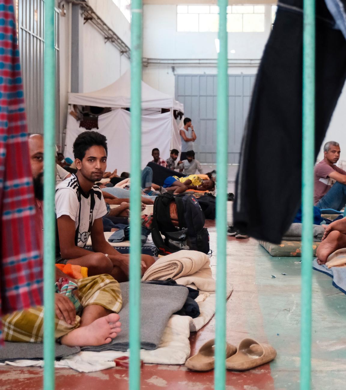 Migranten sitzen in einer provisorisch eingerichteten Unterkunft auf der Insel Kreta.