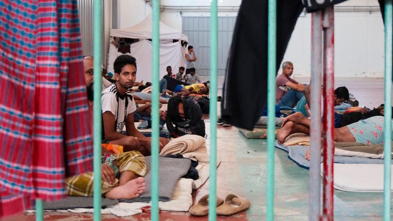 Migranten sitzen in einer provisorisch eingerichteten Unterkunft auf der Insel Kreta.