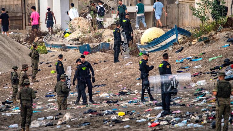 Spanien, Ceuta: Soldaten der spanischen Armee und Beamte der Guardia Civil stehen Wache, während Migranten aus der spanischen Exklave Ceuta nach Marokko zurückkehren.