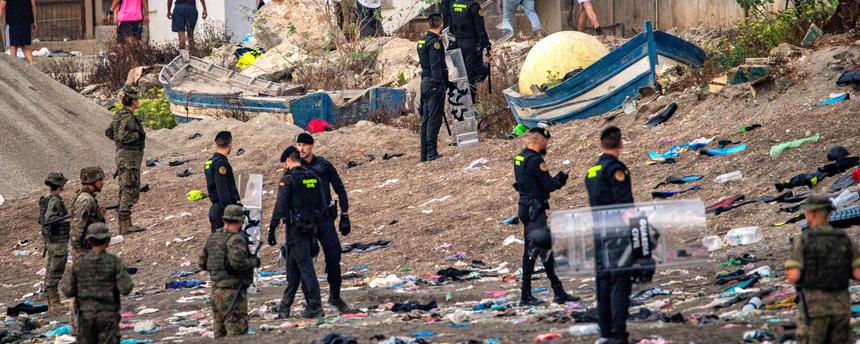 Spanien, Ceuta: Soldaten der spanischen Armee und Beamte der Guardia Civil stehen Wache, während Migranten aus der spanischen Exklave Ceuta nach Marokko zurückkehren.