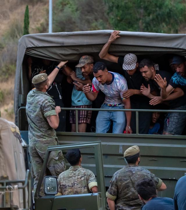Spanien, Ceuta: Migranten, die nach Spanien eingereist sind, werden von spanischen Soldaten in Richtung der spanisch-marokkanischen Grenze begleitet, um von der spanischen Enklave Ceuta nach Marokko zurückgeführt zu werden.