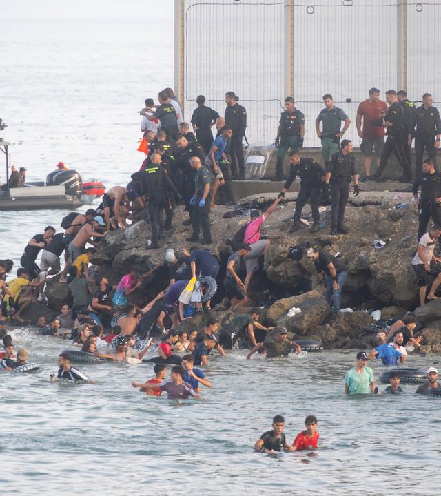 31.07.2026, Spanien, Ceuta: Dutzende Migranten kommen nach dem Überqueren der Grenze in Ceuta an.