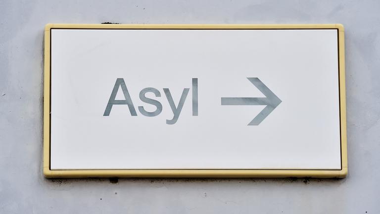 Ein Schild mit der Aufschrift "Asyl" hängt in der Landeserstaufnahme für Asylbewerber (LEA) an einer Wand.
