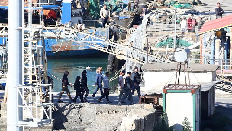 Migranten werden von albanischen Polizisten in ein Auffangcamp in Shengjin begleitet