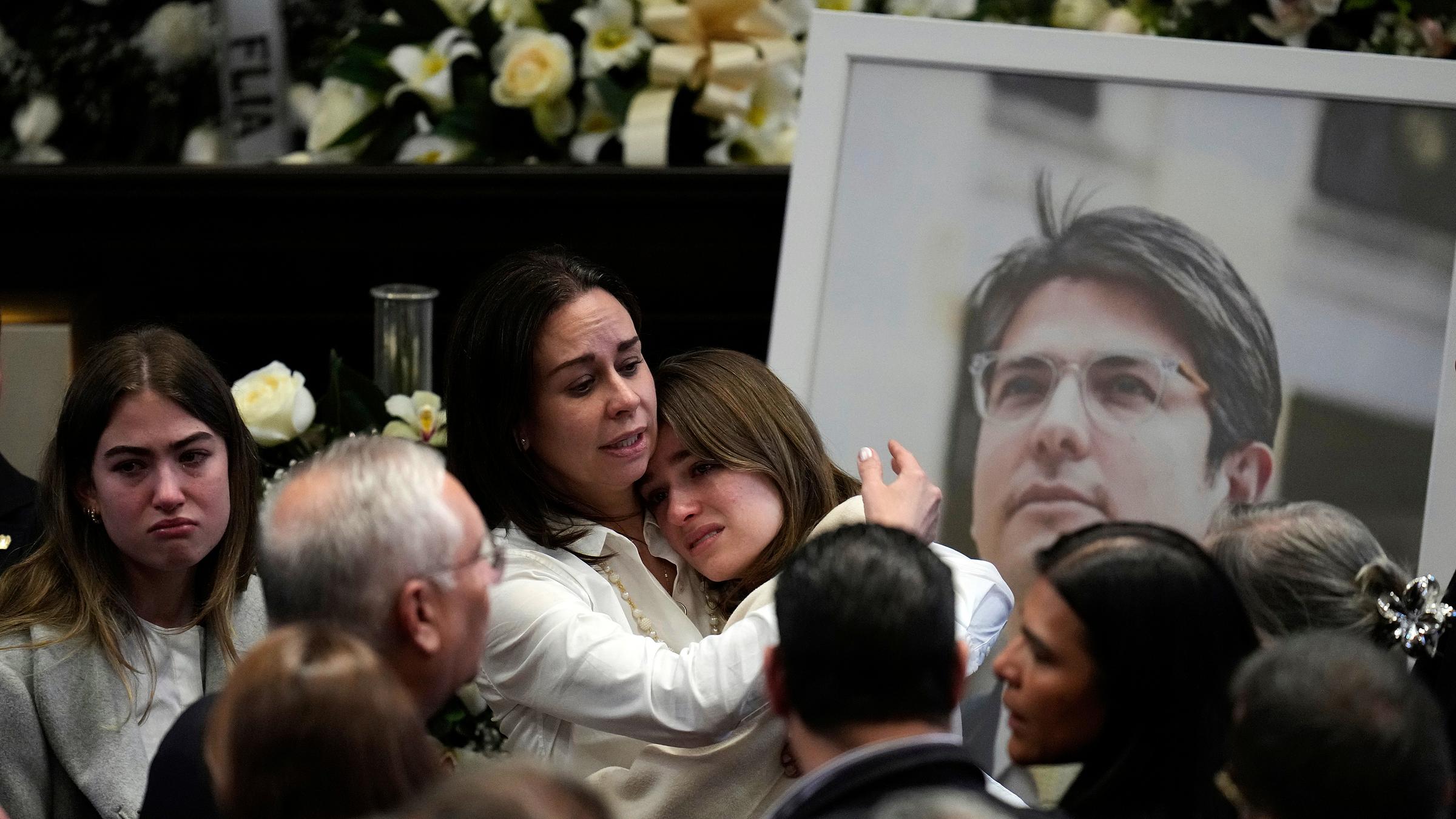 Claudia Tarazona, Ehefrau des Präsidentschaftskandidaten und oppositionellen Senators Miguel Uribe, umarmt eine ihrer Töchter neben einem Foto ihres Mannes während einer Zeremonie zu seinen Ehren im Kongress