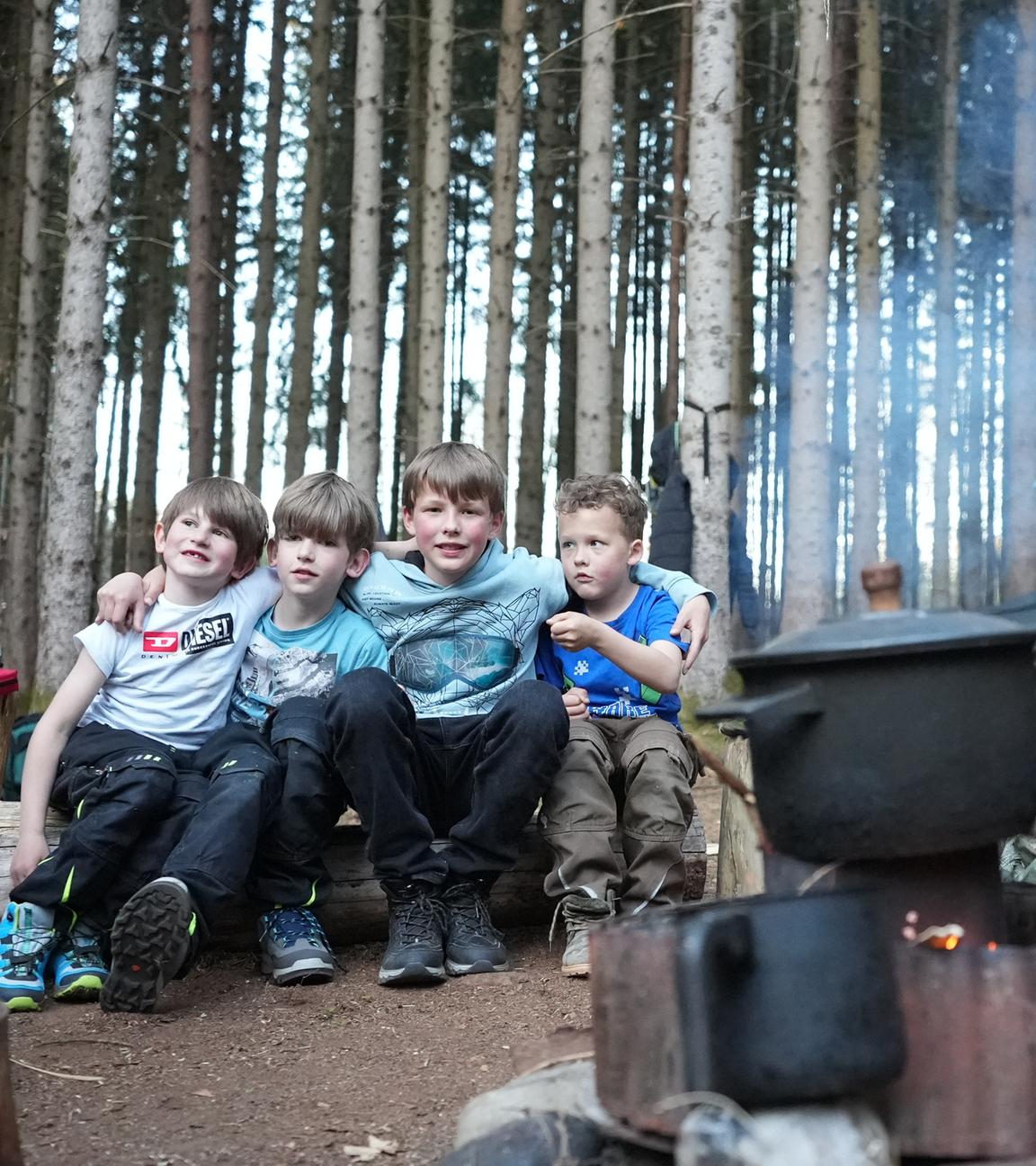 Die Kinder der Familie Scharf-Geßl an der Kochstelle ihres Übernachtungslager im Wald.