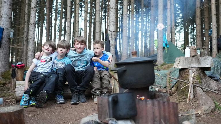 Die Kinder der Familie Scharf-Geßl an der Kochstelle ihres Übernachtungslager im Wald.