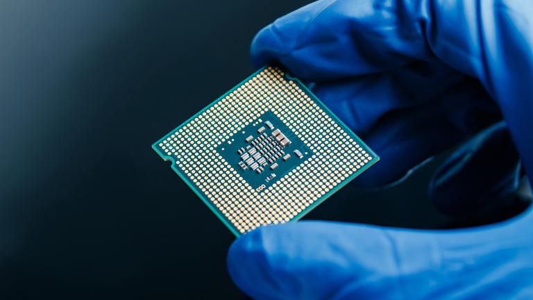 Eine behandschuhte Hand hält einen Halbleiter-Mikrochip