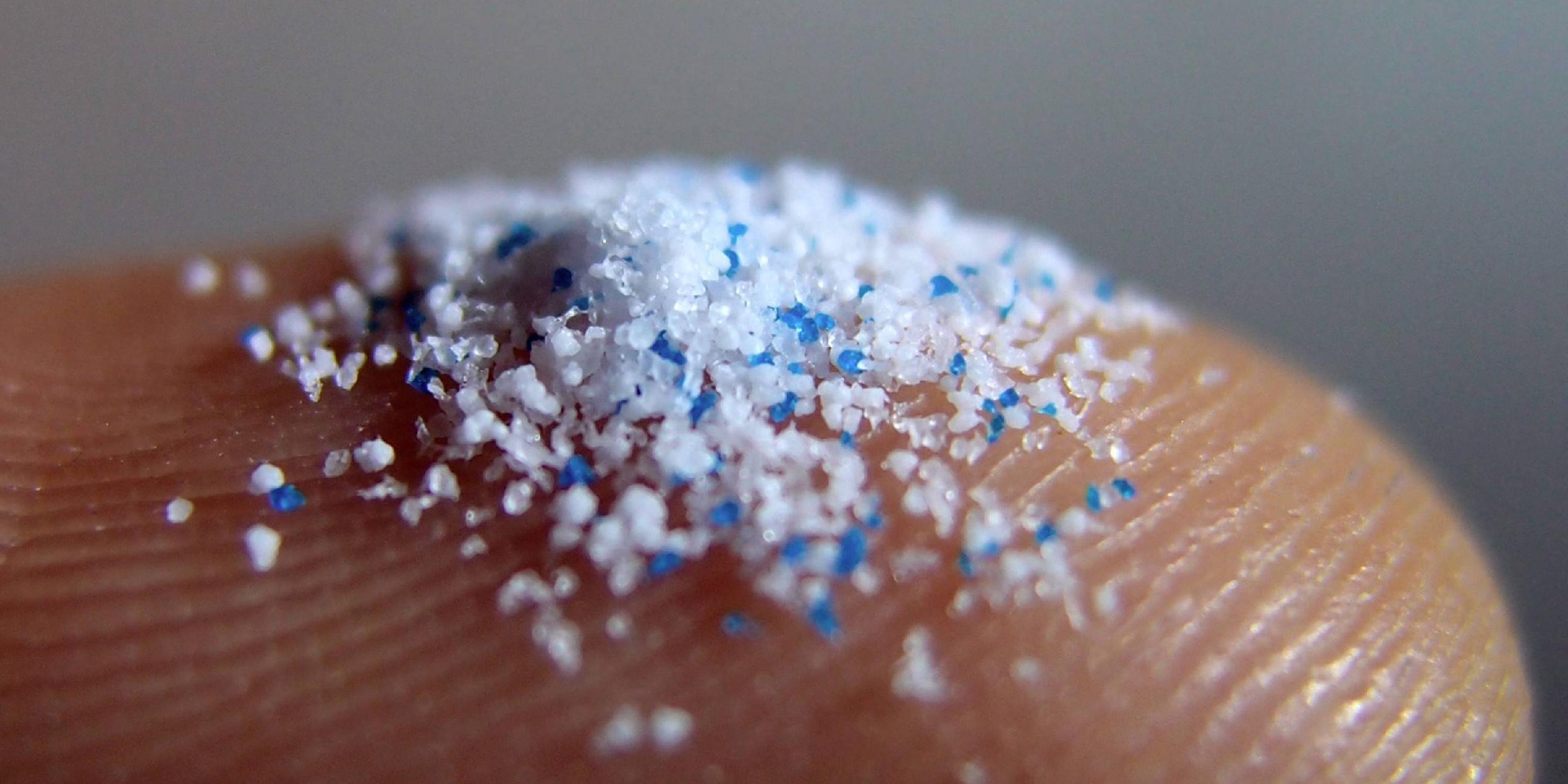 Mikroplastik - kleine Kunststoffpartikel auf einer Fingerspitze.