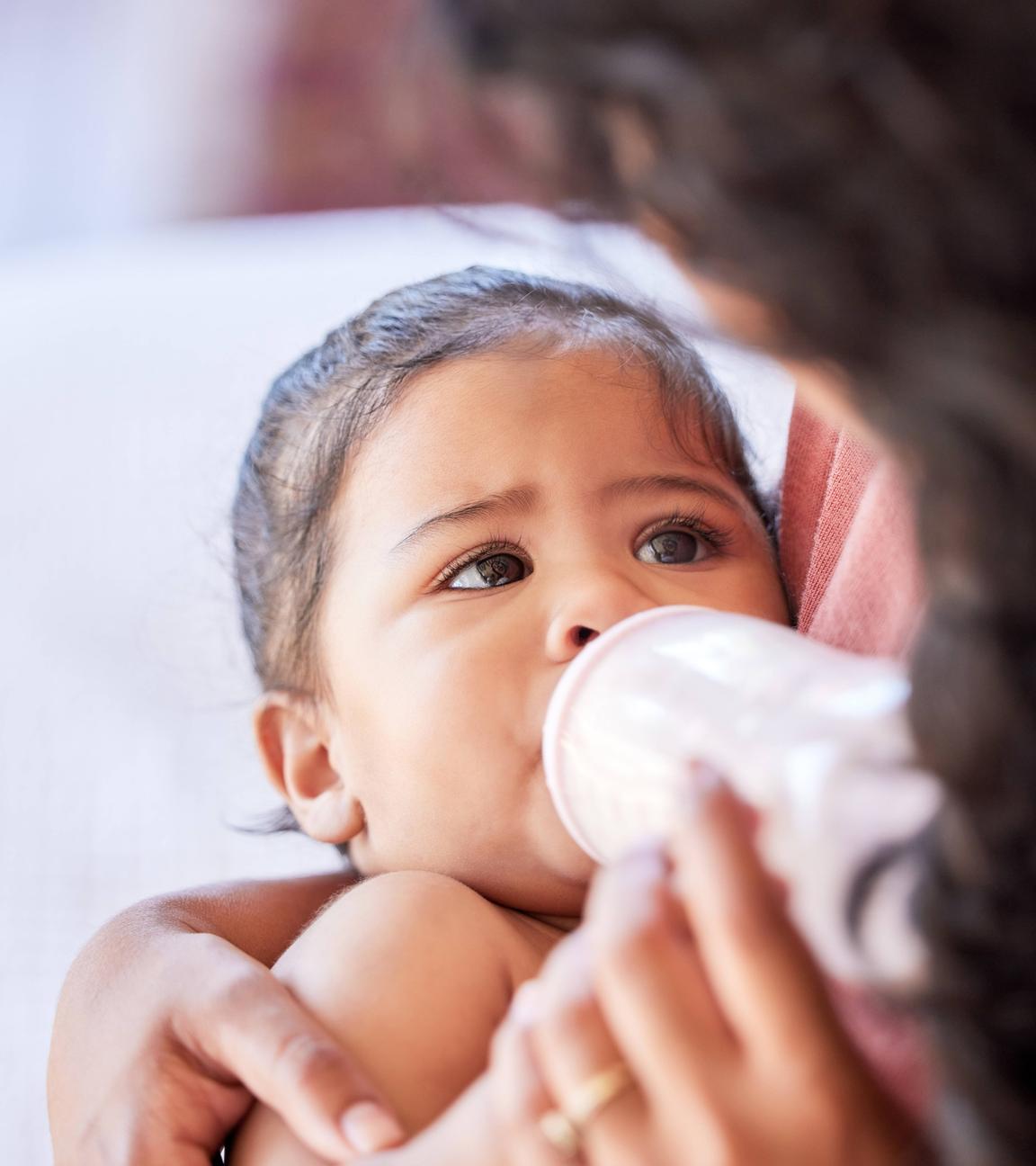 Eine Mutter füttert ihr Baby mit einer Flasche.