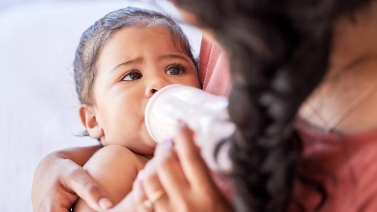 Eine Mutter füttert ihr Baby mit einer Flasche.