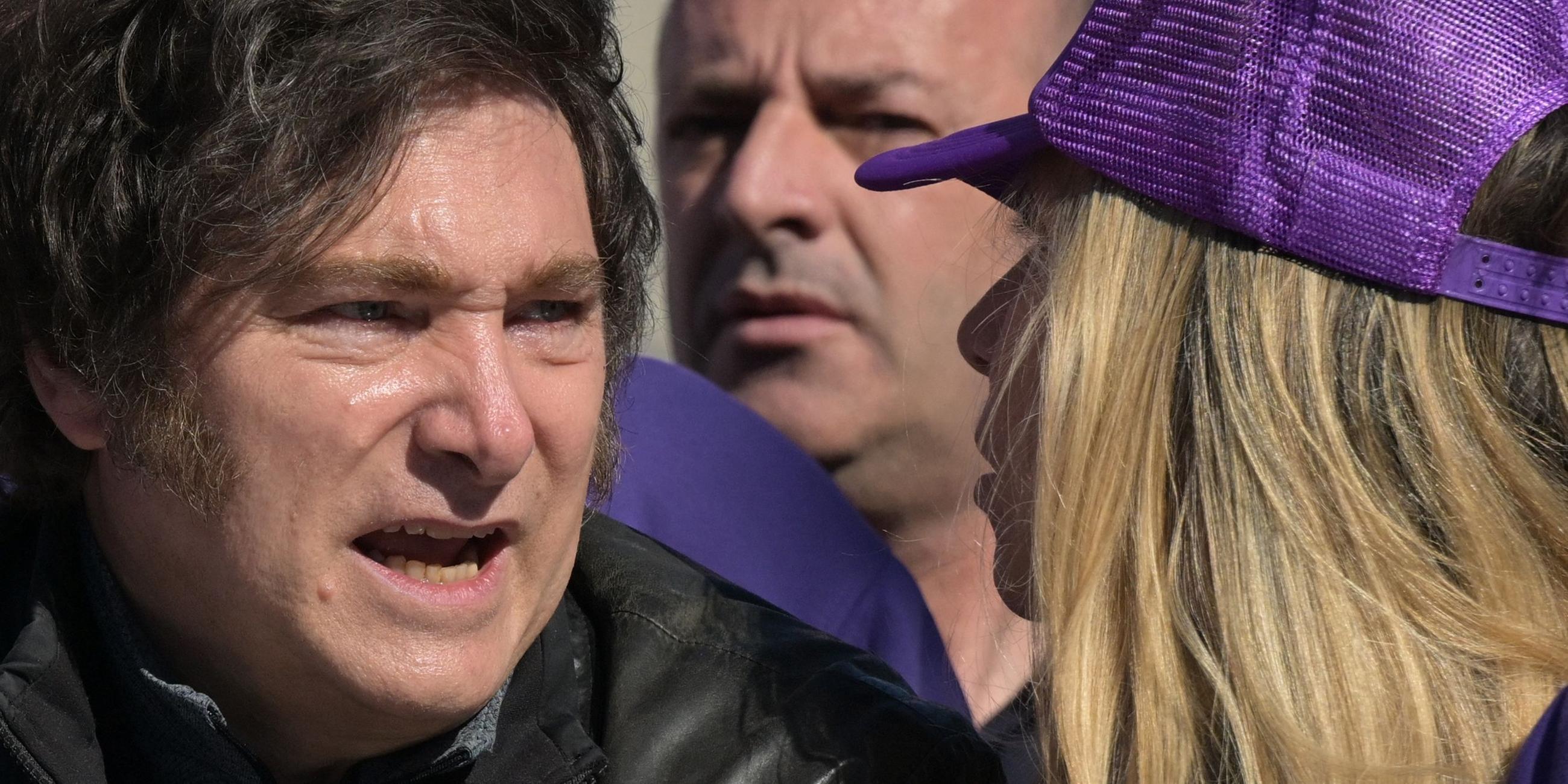 Der argentinische Präsident Javier Milei spricht mit einer Frau