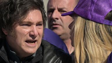 Der argentinische Präsident Javier Milei spricht mit einer Frau