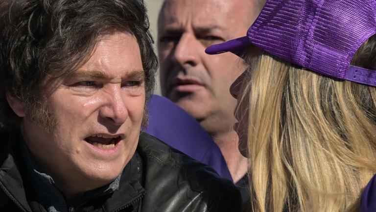 Der argentinische Präsident Javier Milei spricht mit einer Frau