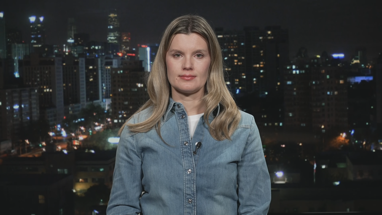 ZDF-Korrespondentin Elisabeth Schmidt vor einer Grafik von Peking bei Nacht