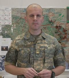 Oberst Markus Reisner vor einer Karte der Ukraine bei der die Front eingezeichnet ist