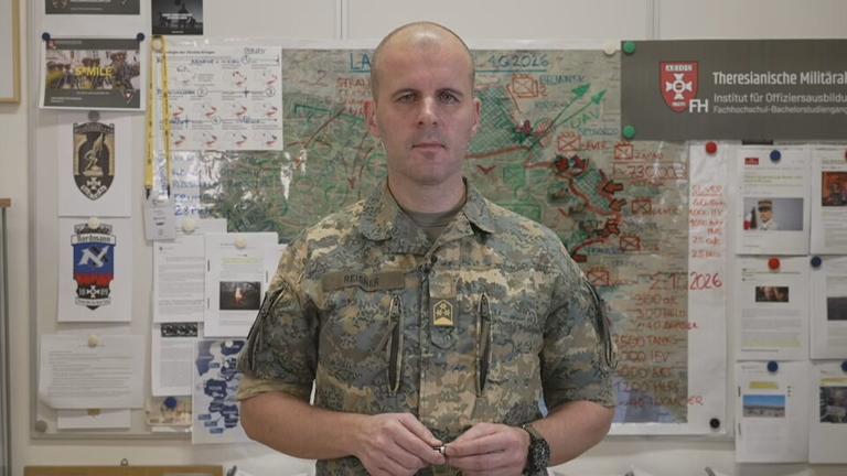 Oberst Markus Reisner vor einer Karte der Ukraine bei der die Front eingezeichnet ist