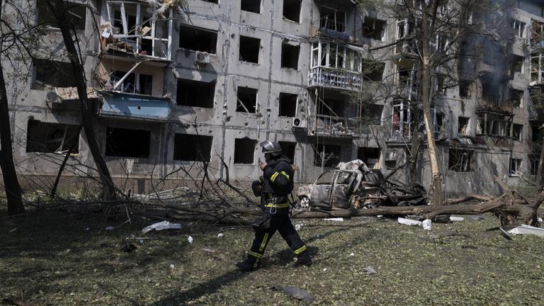 Ein Feuerwehrmann vor zerstörten Häusern 