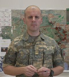 Oberst Markus Reisner vor einer Karte der Ukraine bei der die Front eingezeichnet ist