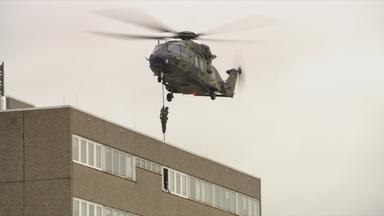 Ein Militärhubschrauber seilt Soldaten ab