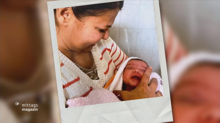 Eine Hebamme hält ein Baby in den Armen