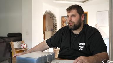 Dirk Laux sitzt am Tisch. Vor ihm liegt aufgeschlagen ein dicker Ordner voller Sammelstücke