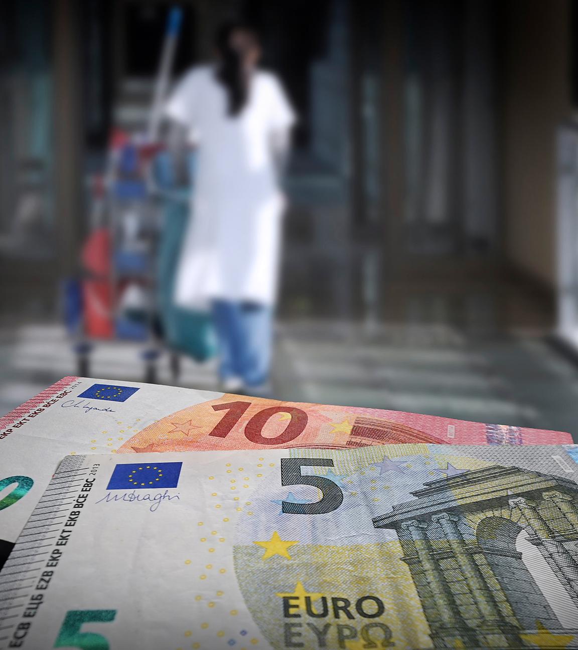 Eine Reinigungsfrau mit Wagen geht durch einen Flur, im Vordergrund sind Geldscheine zu sehen. (Symbolbild)