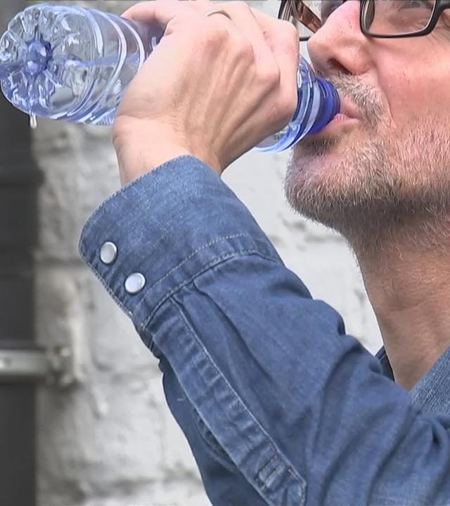 Ein Mann trinkt Wasser.