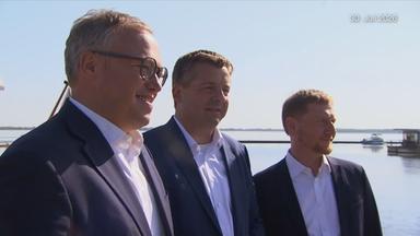 Mario Voigt (links), Ministerpräsident von Thüringen, Sven Schulze (mittig), Ministerpräsident von Sachsen-Anhalt, und Michael Kretschmer (rechts), Ministerpräsident von Sachsen stehen neben einander.