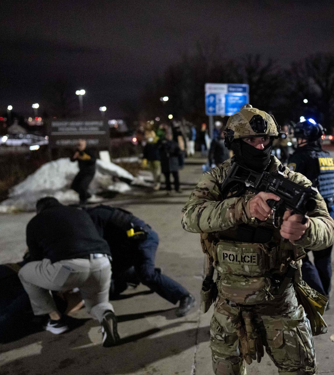 Bundesbeamte der Einwanderungsbehörde nehmen einen Demonstranten vor dem Bishop Henry Whipple Federal Building fest.