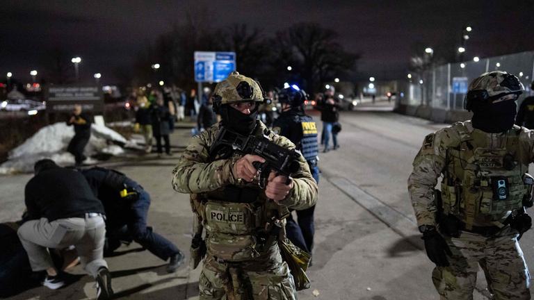 Bundesbeamte der Einwanderungsbehörde nehmen einen Demonstranten vor dem Bishop Henry Whipple Federal Building fest.