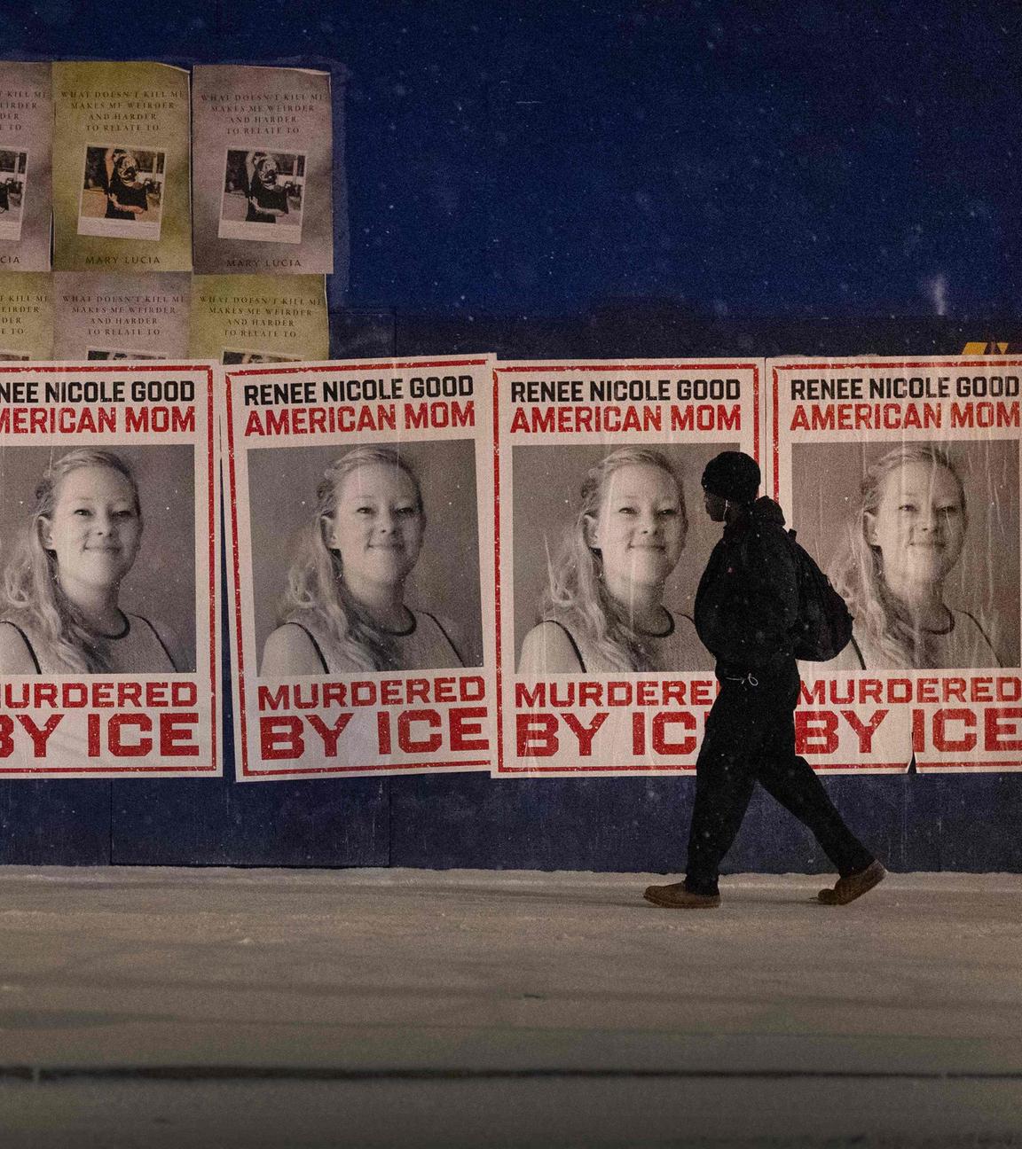 Eine Person läuft vor einer Reihe von Plakaten, auf denen "Renee Nicole Good, American Mom, Murdered by ICE" zu lesen ist.