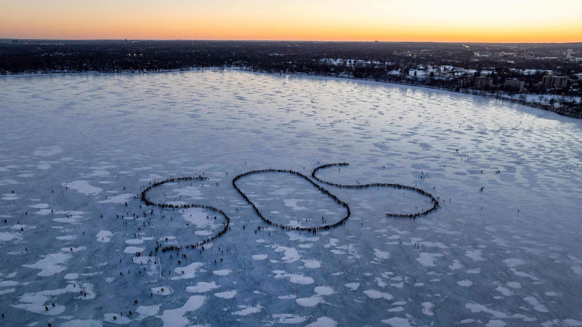 Demonstranten bilden auf einem zugefrorenen See in Minneapolis ein SOS-Notrufzeichen