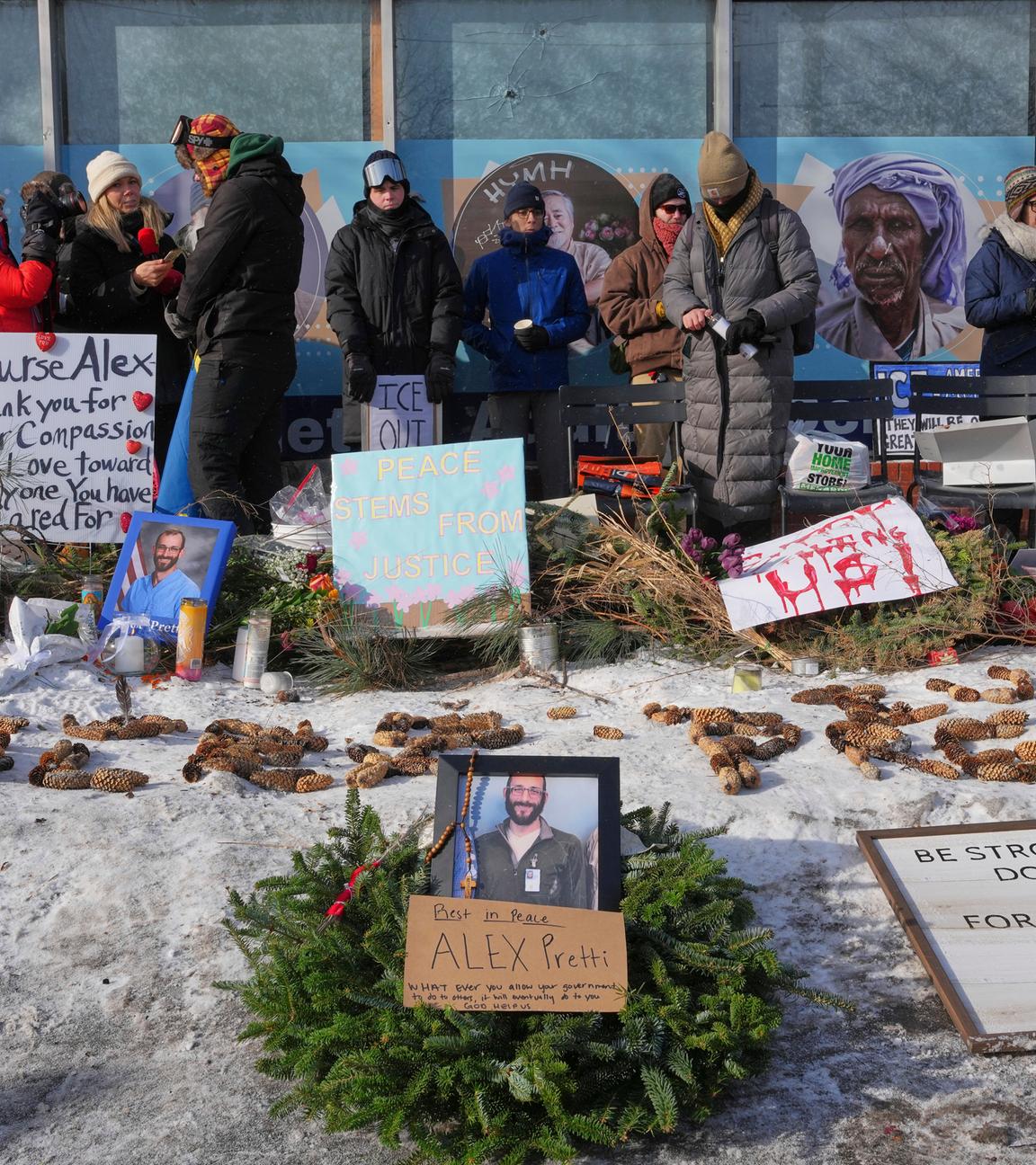 Menschen Gedenken einem Todesopfer in Minessota. Auf dem Boden sind Blumen und Bilder vom Opfer zu erkennen.