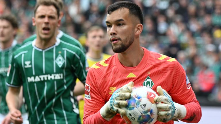 Torwart Mio Backhaus (Werder Bremen) fängt den Ball.