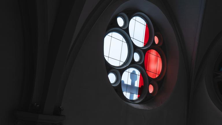 Bei einer Solidaritätsaktion mit den Missbrauchsopfern der katholischen Kirche wirft das Licht den Schatten eines Kreuzes durch eines der Fenster der Kirche Maria Geburt